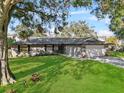 Charming single-story home with a well-manicured lawn and a two-car garage, framed by mature trees at 4570 Chambliss Rd, Winter Haven, FL 33884