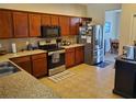 Well-equipped kitchen with stainless steel appliances, wood cabinets, and granite countertops at 2712 Oak Hammock Loop, Mulberry, FL 33860