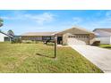 Inviting single-story home featuring stone accents, a two-car garage, and a verdant lawn at 288 Hernando Rd, Winter Haven, FL 33884