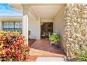 Inviting front porch with tiled flooring, stone accents, and decorative plants at 288 Hernando Rd, Winter Haven, FL 33884