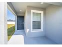 Covered front porch with dark gray door and a window with blinds at 4364 Reding Way, Lakeland, FL 33813