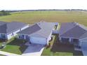 Single-story house, gray exterior, two-car garage, and fenced backyard at 566 Valentina Ln, Auburndale, FL 33823