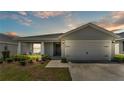 Charming single-story home with a well-manicured lawn, covered entry, and a two-car garage at 566 Valentina Ln, Auburndale, FL 33823