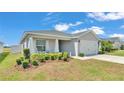 Charming single-story home featuring a well-manicured lawn, a two-car garage, and a cozy front porch at 566 Valentina Ln, Auburndale, FL 33823