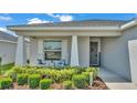 Inviting front porch with rocking chairs and manicured landscaping, creating a cozy curb appeal at 566 Valentina Ln, Auburndale, FL 33823