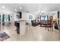 Bright living room featuring tile floors, comfortable seating, and an open layout at 1924 Amber Sweet Cir, Dundee, FL 33838