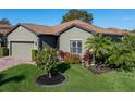 Landscaped home with a two-car garage and lush green lawn at 4076 Tralee Dr, Lake Wales, FL 33859