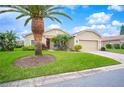 Tan house with palm trees, a brown door, and a two-car garage at 4151 Muirfield Loop, Lake Wales, FL 33859