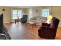 Bright living room with hardwood floors, comfy seating, and large windows at 6308 Bayberry Ne Blvd, Winter Haven, FL 33881