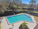 Community pool with lounge chairs, umbrellas, and surrounding patio at 111 Woden Way, Winter Haven, FL 33884