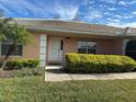 Front entrance of a tan house with landscaping at 137 Harbor Way, Auburndale, FL 33823