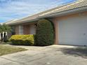 White garage and part of tan house exterior at 137 Harbor Way, Auburndale, FL 33823