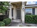 Gray front door entry with black shutters and landscaping at 1548 Normandy Heights Blvd, Winter Haven, FL 33880