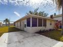 Tan house with a screened porch and a concrete patio at 162 N 2Nd St, Eagle Lake, FL 33839