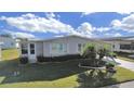 Single-wide manufactured home with carport and landscaped yard at 1716 Quail Hill Dr, Lakeland, FL 33810