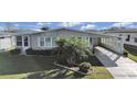 Single-wide manufactured home with carport and landscaped yard at 1716 Quail Hill Dr, Lakeland, FL 33810