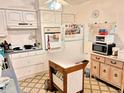 Galley kitchen with white cabinets and appliances at 1865 4Th Se St, Winter Haven, FL 33880