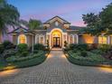 Elegant home exterior featuring a landscaped yard and a paver walkway leading to the front door at 221 Mclean Pt, Winter Haven, FL 33884