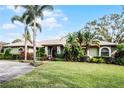 Landscaped one-story home with palm trees and a circular driveway at 2428 Wildwood Ct, Winter Haven, FL 33884