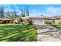 Single-story home with attached garage and lush landscaping at 38 Grenewood Ln, Haines City, FL 33844