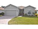 Single-story house with a two-car garage and well-manicured lawn at 4413 Strathmore Dr, Lake Wales, FL 33859