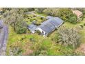 Aerial view shows a single-story house with a large backyard and surrounding trees at 48 Nottingham Way, Haines City, FL 33844
