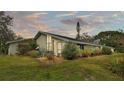 View of the home's side showcasing unique architectural details and lush greenery at 48 Nottingham Way, Haines City, FL 33844