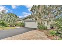 House exterior with a two-car garage, landscaping, and a paved driveway at 48 Nottingham Way, Haines City, FL 33844