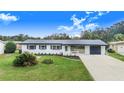 Newly renovated home with white siding, black trim, and a spacious driveway at 5524 Meander Dr, Lake Wales, FL 33898