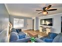 Living room with gray sofas, wood floors, and TV at 86 Winter Ridge Rd # 86, Winter Haven, FL 33881