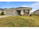 Gray house with a two-car garage, small porch, and well-manicured lawn at 1042 Corso Dr, Winter Haven, FL 33884