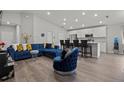 Open living room with a sectional sofa, accent chair, and kitchen island at 1042 Corso Dr, Winter Haven, FL 33884