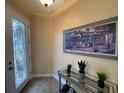 Inviting entryway with a decorative glass front door, tiled floor, console table and attractive wall art at 1068 Stoney Creek Dr, Lakeland, FL 33811