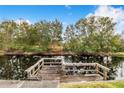 Wooden dock extending over calm water, surrounded by lush trees at 13901 Hatchineha Rd, Haines City, FL 33844