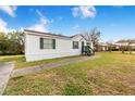 Side view of the home, showcasing its white exterior and green trim at 13901 Hatchineha Rd, Haines City, FL 33844