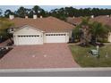 Aerial view of a two-car garage villa with a brick driveway at 1649 Linz Ct, Winter Haven, FL 33884