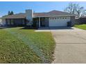 Ranch-style home with a two-car garage and well-maintained lawn at 2314 York Pl, Lakeland, FL 33810