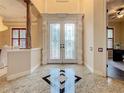 Elegant entry with double doors, granite flooring, and high ceilings at 2683 Wyndsor Oaks Way, Winter Haven, FL 33884