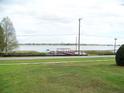 Lush green lawn view to waterfront property featuring a private dock and stunning lake views at 333 Lake Howard Nw Dr # 202-A, Winter Haven, FL 33880