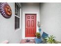 Inviting front entry with red door, plants, and patio chairs at 3946 Bedford Ave, Winter Haven, FL 33884
