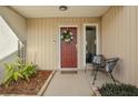 Inviting front entry with red door, wreath, and small sitting area at 3966 Oak Loop # 13, Mulberry, FL 33860