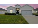 Charming home featuring a two-car garage, a well-manicured lawn, and inviting front entrance at 425 Riders Loop, Auburndale, FL 33823
