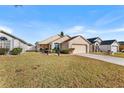 Tan one-story house with a two-car garage and grassy yard at 426 Allison Ave, Davenport, FL 33897