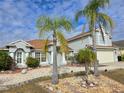 Two-story house with palm trees, landscaping, and a beige exterior at 437 Grand Reserve Dr, Davenport, FL 33837