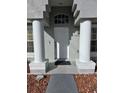 White front door with columns and a walkway at 437 Grand Reserve Dr, Davenport, FL 33837
