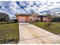 Damaged house with pink garage door and overgrown yard at 517 Cipres Cir, Winter Haven, FL 33880