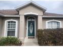 House entrance with teal door and landscaping at 551 Heather Glen Dr, Winter Haven, FL 33884