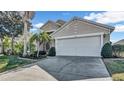 Two-story house with a white garage door and palm trees at 1153 Legatto Loop, Dundee, FL 33838