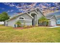 Gray house with landscaped yard, palm trees, and a two-car garage at 1932 Southern Dunes Blvd, Haines City, FL 33844