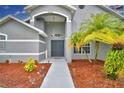 Double front doors with a walkway and palm trees at 1932 Southern Dunes Blvd, Haines City, FL 33844